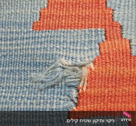 שטיח כחול עם קרע וחוטים פרומים
